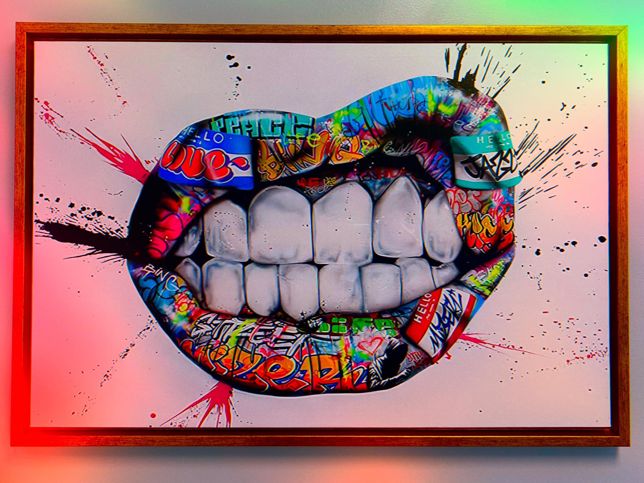 Colorful graffiti-style lips and teeth artwork with gold frame and LED backlighting inside the Advanced Teeth Whitening studio